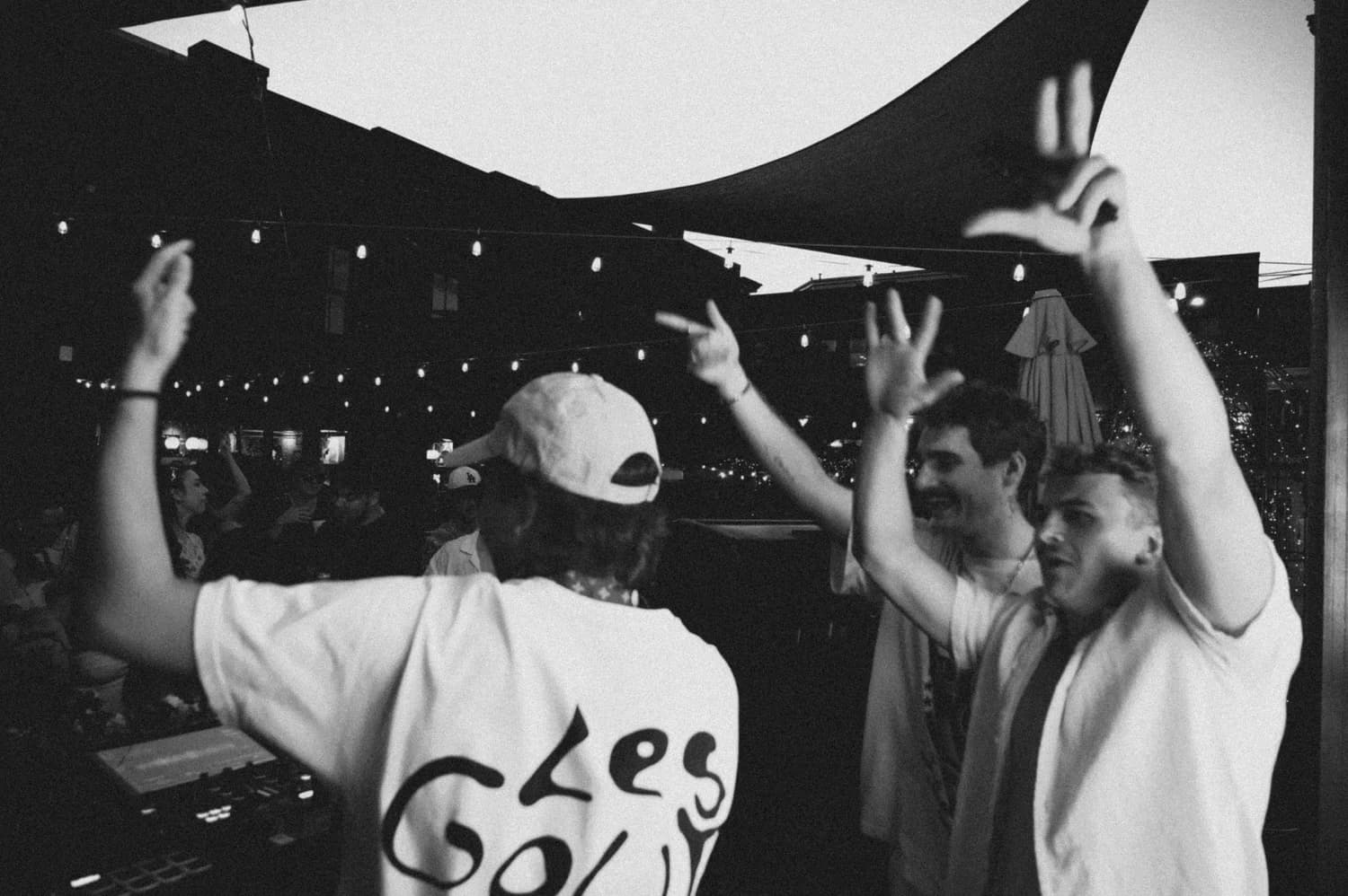 The crowd throwing their hands in the air in front of the DJ booth