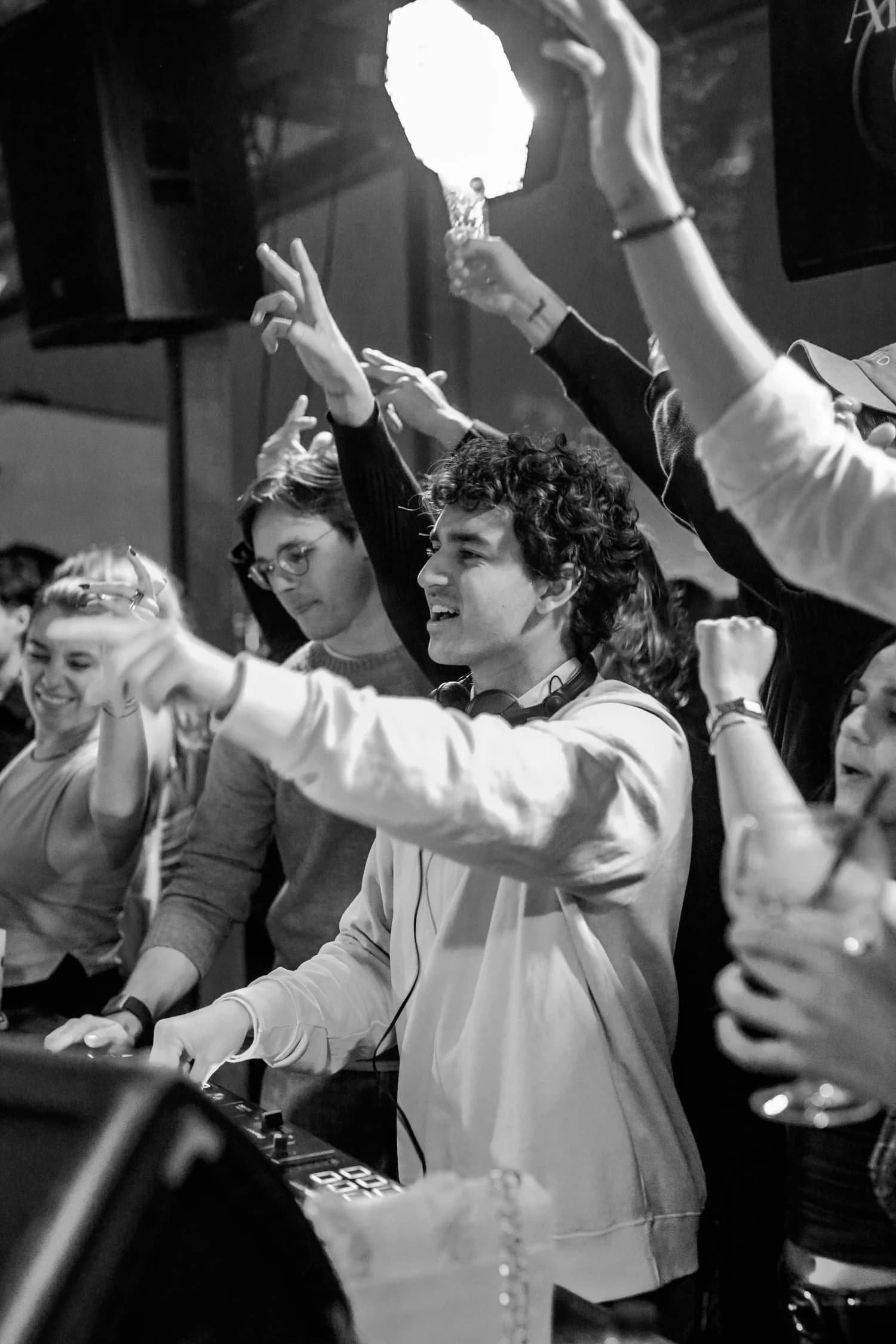 Hands up across the crowd in front of the decks
